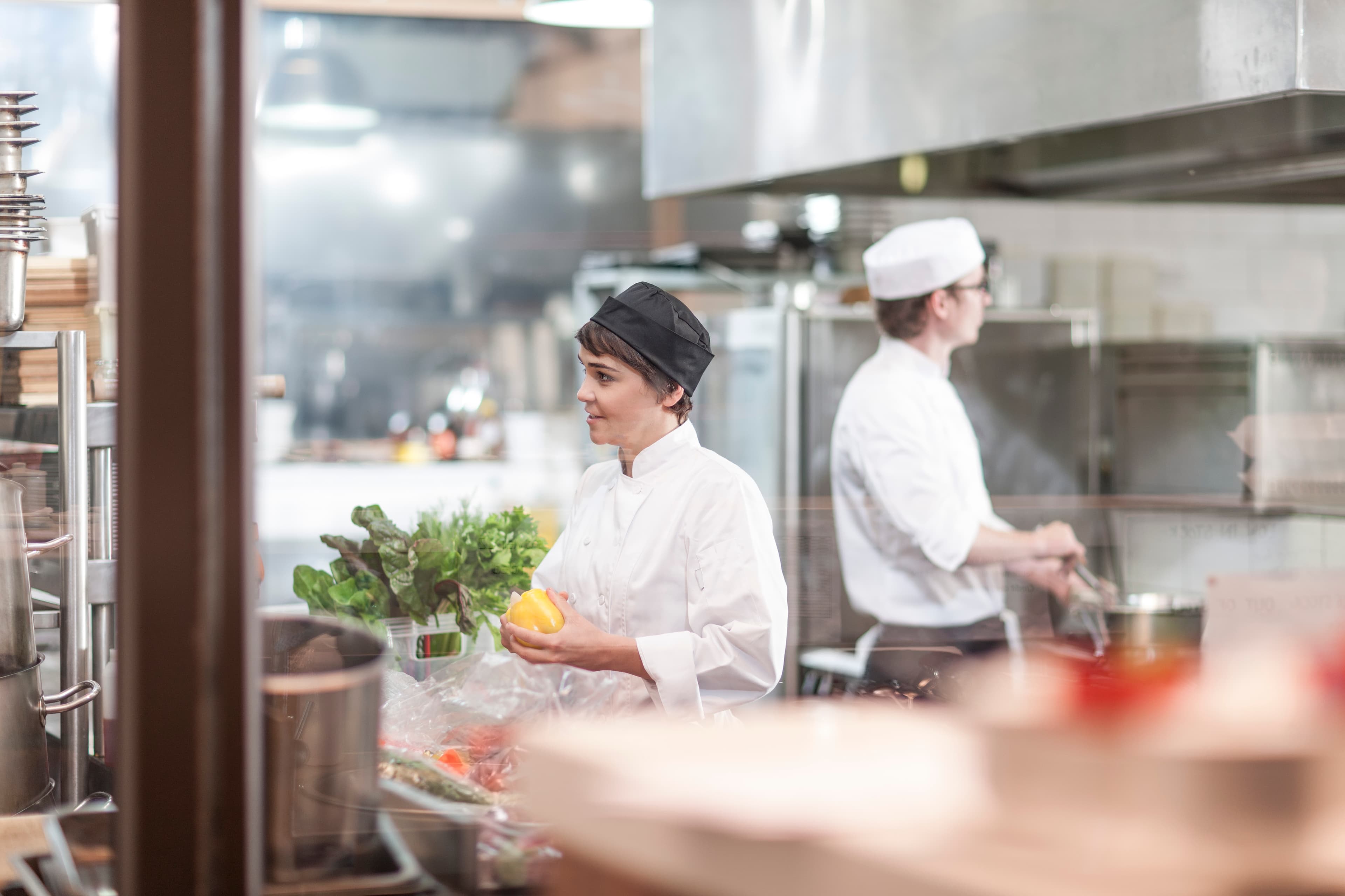Two chefs working through a stainless pass — the works in service
